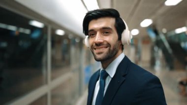 Akıllı bir iş adamı tren istasyonunda kulaklık takarken telefon eder. Profesyonel yönetici, tren ya da metro beklerken pazarlama stratejisi hakkında meslektaşıyla konuşuyor. Sevinçli..