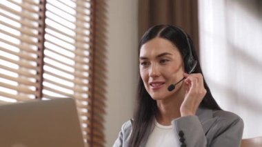 Kadın çağrı merkezi operatörü ya da müşteri hizmetleri çalışanı, müşteriye yardım etmek için kulaklıkla konuşurken çalışma alanı üzerinde çalışıyor. Profesyonel modern iş hizmeti. Blithe