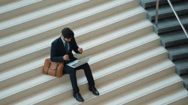 Üst düzey bir iş adamı merdivenlerde otururken başarılı bir projeyi kutluyor. Proje yöneticisi yeni bir pozisyon alıyor, terfi alıyor, arkadaşlarını ararken dizüstü bilgisayar kullanarak satışları artıyor. Sevinçli..