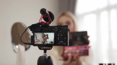 Güzellik ve kozmetik öğretim videosu içeriği yapan kamera görüntüsü kadını ya da perde arkası görüntüsü. Güzellik blogcusu izleyicilere ya da sosyal medya takipçilerine güzellik hizmetinin nasıl uygulanacağını gösteriyor. Blithe