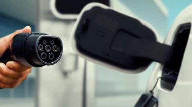 Kameranın önüne odaklanmış EV şarj cihazı fütüristik akıllı dijital EV batarya durum hologramını gösteriyor. EV araba şarjı sürdürülebilir güç için alternatif enerji kullanıyor. İnceleyin