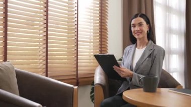 Mutlu ve gülümseyen kadın psikolog psikiyatri ofisinde ya da terapi odasında pano tutuyor. Arkadaş canlısı ve profesyonel ruh sağlığı danışmanı ya da terapisti. Blithe