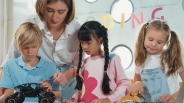 Öğretmen öğrencilere dijital elektrikli aletleri ya da araba modelini öğretir ve açıklar. Çeşitli çocuklar elektronik aletleri öğrenip ana kartı ya da kablolu robot modelini tamir etmeyi öğrenirler. Etkinlik.