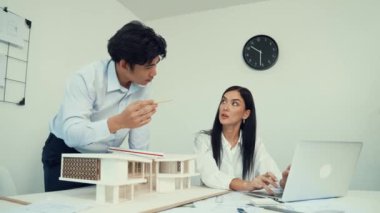 Happy, mimari belge ve ev modeli ile toplantı masasında dizüstü bilgisayar analiz verilerini kullanarak birlikte çalışan profesyonel mimar takımı ile işbirliği yapıyor. Yaratıcı tasarım konsepti. Tertemiz..