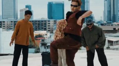 Çatıda çok kültürlü arkadaşlar varken profesyonel İspanyol break dansçısı B boy dansı. Genç modern dans grubu hip hop hareketi yapıyor. Tarz, moda, aksiyon. Açık hava sporu 2024 hiphop..