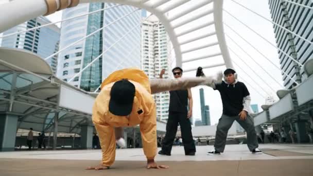 低角度相机的快乐嬉皮士一边跳舞一边看相机 街头舞蹈演员在朋友的簇拥着下表演霹雳舞 在城市里受到朋友的鼓励 自由式舞 2024年户外运动 神气活现 — 图库视频影像