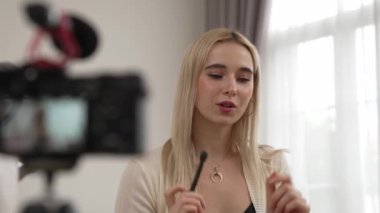 Güzellik ve kozmetik öğretim videosu içeriği yapan kamera görüntüsü kadını ya da perde arkası görüntüsü. Güzellik blogcusu izleyicilere ya da sosyal medya takipçilerine güzellik hizmetinin nasıl uygulanacağını gösteriyor. Blithe