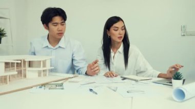 Genç, zeki, yakışıklı mühendis ev modelini ölçerken genç, beyaz, iç tasarımcı önemli noktayı işaret ediyor. Birlikte çalışıyoruz, takım olarak çalışıyoruz. Yaratıcı tasarım konsepti. Tertemiz..