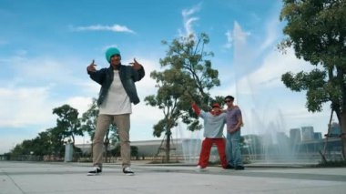 Profesyonel çekici hipster, Fountain ile sokak dansı yapıyor. Yakışıklı bir adamın B-boy ayak egzersizi sahnesi. Mavi arka plan. Modern yaşam tarzı. Açık hava sporu 2024. Yumuşak bir şekilde..