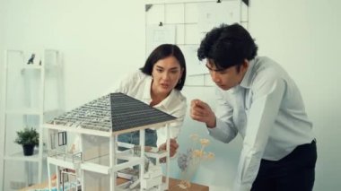 Profesyonel kooperatif beyaz mimar mühendis ekibi ev modelini dikkatle incelerken beyaz modern ofisteki model yapısı hakkında tartışırlar. Yaratıcı karar ve takım çalışması. - Yakın çekim. Tertemiz..