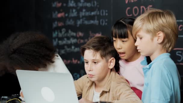 在黑板上的Stem技术教室里 男孩们用笔记本电脑编程 编写工程代码和编写程序 而一群聪明的 多样化的学生站在朋友的身边 Erudition — 图库视频影像