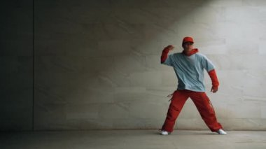 Profesyonel Asyalı hipster gri arka planlı break dansçı performansı sergiledi. Çekici bir sokak dansçısı şık kıyafetler giyerken hareketli hareketler yapar. Açık hava sporu 2024. Uzayı kopyala Yumuşak bir şekilde..