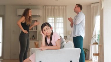Sinirli ve mutsuz genç bir kız oturma odasında ebeveyninin tartışması yüzünden gerginliğin ortasında kanepede oturuyor. Sağlıksız ev hayatı ve travmatik çocukluk depresyona dönüşür.