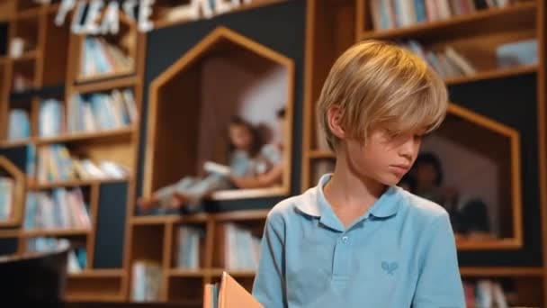 Привабливий Білий Хлопчик Читає Книгу Група Розумних Студентів Сидить Бібліотеці — стокове відео