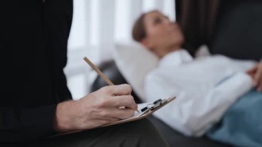 Çömelmiş yatmakta olan genç bir kadın hasta ofiste zihinsel tedavi sırasında travmatik bir olay, endişe ve akıl hastalığından psikiyatriste duygu salıyor. Psikolojik danışma seansı. Düzenle