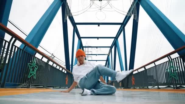 직업적인 브레이크 댄서는 교량에 발걸음을 실행합니다 포즈를 아시아 힙스터 헤드폰 — 비디오