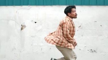 İspanyol komedi koreografı hip hop tarzında dans ediyor. Genç mutlu break dansçı B-boy dansı yapıyor. Sokak dansı yapan komik adamın hareket çekimi. Açık hava sporu 2024. Modern dans. hiphop.