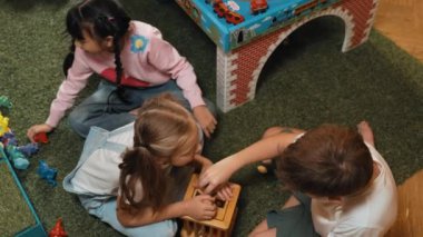 Anaokulunun oyun odasında ahşap blok oynayan çok kültürlü ve zeki öğrencilerin en iyi görüntüsü. Çeşitli çocuklar yaratıcılığı ve hayali geliştirmek için oyuncak oynarlar. Yaratıcı aktivite konsepti. Etkinlik.