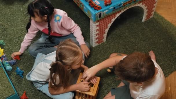 幼稚園の遊び場で木製のブロックを一緒に遊ぶ多文化スマートな学生のトップビュー 多様な子供たちが創造性と想像力を向上させるおもちゃをプレイしています クリエイティブ活動コンセプト エラー — ストック動画