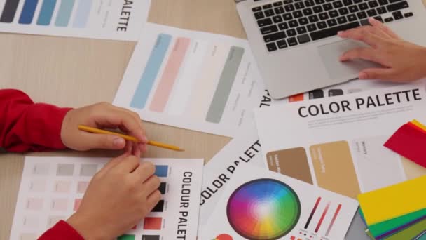 顶部视图慢动作手特写在两个设计师的桌子上 为平面设计工作选择颜色 或客户在设计师创造性的色彩咨询中寻找颜色应用 — 图库视频影像