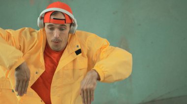 Kafkas hippilerin yakın plan görüntüsü sokak, şehir merkezinde ayak sesleri gösteriyor ya da pratik yapıyor. Genç break dansçının hareket eden kol ve bacağının hareketli çekimi. Açık hava sporu 2024. Gri arka plan. ÇalışmaComment.