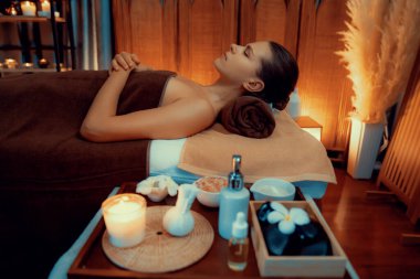 Beyaz kadın müşteri stres önleyici spa masajının keyfini çıkarıyor ve lüks otel ya da otelde sıcak mum ışığında güzellik teniyle eğleniyor. Sessiz.