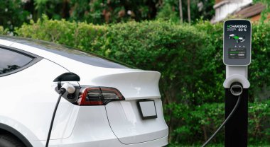 Elektrikli taşıt teknolojisi, EV araba aküsünün şarj edilmesi için konut istasyonunda kullanılıyor. Gelecekteki çevre için temiz ve sürdürülebilir enerji ile çevre dostu ulaşım. Panorama Senkronizasyonu