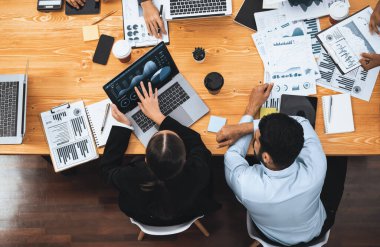 Panorama üst görüşlü çok ırklı analist ekibi, stratejik karar için finansal verileri analiz etmek amacıyla dizüstü bilgisayarda BI gösterge panelini kullanıyor. Fintech pazarlama göstergelerini analiz ediyor. Uyum