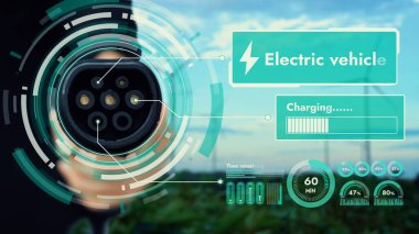 Kameranın önüne odaklanmış EV şarj cihazı bulanık iş adamlarının el rüzgar türbini çiftliği ile batarya durum hologramını gösteriyor. Karbondioksit salınımını azaltmak için temiz enerji kullanan elektrikli araba şarjı tıpası.