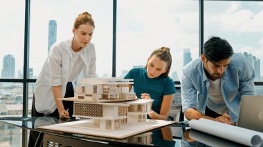 Akıllı mimar takımı ev tasarımı hakkında tartışırken yakışıklı erkek işçi dizüstü bilgisayar kullanarak fikir sunuyor. Profesyonel mühendis paylaşımı, beyin fırtınası tasarımı. İş tasarımı. İzleme