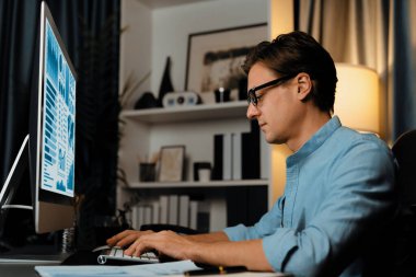 Akıllı iş adamı iş paragrafı dinamik pazarlama analizi planını analiz ediyor. Kağıt kağıtları ve bilgisayar monitörü raporlarını gece evdeki belge verileriyle karşılaştırmak için hazırlıyor. Bireysel.