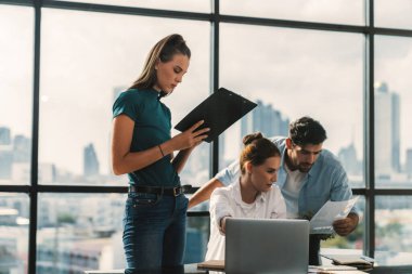 Bir grup profesyonel iş adamı pazarlama fikri üretiyor. Genç ve güzel yönetici iş arkadaşının buluşmada fikir paylaşımını dinlerken dizüstü bilgisayara bakıyor. Birlikte çalışmak. Gökdelen manzaralı. İzleme.