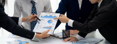 Grup toplantısındaki iş adamları resmi kıyafet paylaşımı fikrine sahipler. Şirketin yaratıcı çalışma alanındaki kar raporunu tartışıyorlar. Grup toplantısı masasında yakın çekim yapmak için. Konuşma .