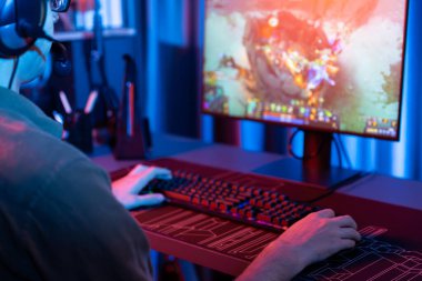 Savaş arenasında çoklu oyunlar takımıyla Moba 'da savaşan genç oyun flamasının sunucu kanalı, neon dijital ışık modern odasındaki arka görüntü ile bilgisayar monitöründe kulaklık takıyor. Toplayıcı.