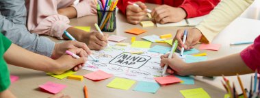 Yaratıcı iş adamları, zihin haritalama kullanarak pazarlama stratejisi ve iş planı hakkında beyin fırtınası yapıyorlar. Girişim ekibi kağıda yazmak için birlikte çalışır. Eline odaklan. - Yakın çekim. Değiştirilmiş.