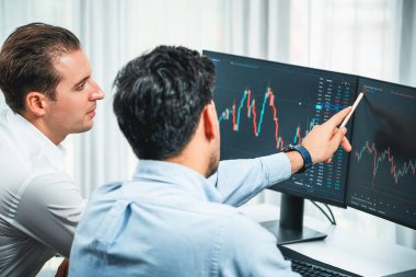 Yatırımcı hisse senedi işçisi, dinamik döviz kuru veritabanı grafiğindeki yatırım eğilimini monitör ekranı ile analiz ediyor. Mevcut durum krizinde bilgi paylaşımı kar ve zarar. Satılabilir.