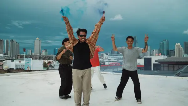 一群多文化的嬉皮士在屋顶上玩彩灯 迷人的街头舞者手握彩烟 跳霹雳舞 跳嘻哈音乐 2024年户外运动 奋斗者 — 图库照片