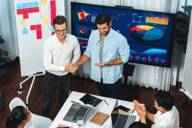 Analist ekip lideri, iş zekası ya da BI gösterge paneli ile FIntech yazılım gücünü kullanarak başarılı veri analizi toplantısından sonra iş arkadaşıyla tokalaştı. Tedbirli