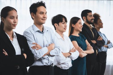 Profesyonel iş adamlarından oluşan çeşitli gruplar modern kurumsal ofiste çapraz kol hareketi ile sırada bekliyor. Mutlu ve gülümseyen, çok ırklı ofis çalışanı ekip birleşmesi ve birlikte başarılı. Uyum