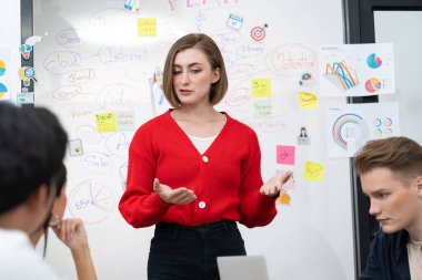 Profesyonel çekici kadın lider, modern iş toplantı odasında beyin fırtınası zihin haritalama istatistikleri ve renkli yapışkan notlar kullanarak yaratıcı pazarlama planını sunuyor. Tertemiz..