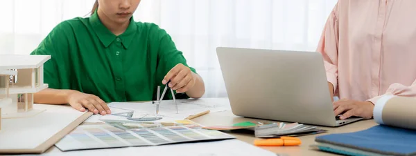 熟练的室内设计人员使用建筑设备绘制蓝图 室内设计人员使用笔记本电脑仔细选择合适的颜色 创意设计和团队合作的概念 — 图库照片
