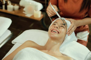 Güzeller güzeli beyaz kadın güzellik teçhizatı ve tıbbi ekipmanlarla çevrili modern kaplıca salonundaki profesyonel eller tarafından masaj yaptırırken spa yatağında uzanıyor. Kapatın. Huzur