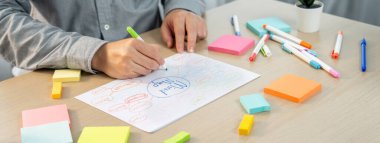 Yetenekli iş adamları zihin haritaları kullanarak pazarlama fikirleri üretiyor. Başarılı erkek girişim lideri masaya yapış yapış notlar serpiştirerek finansal plan hazırlıyor. - Yakın çekim. Eline odaklan. Değişik..