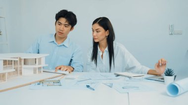 Profesyonel erkek mühendis ev modelini cetvel kullanarak ölçerken güzel bir kooperatif iş arkadaşı verileri analiz etmek için dizüstü bilgisayar kullanarak birlikte çalışıyor. Yaratıcı tasarım ve takım çalışması. - Yakın çekim. Tertemiz..