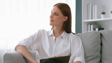 Psikiyatri ofisinde ya da terapi odasında kol koltuğunda oturan profesyonel bir kadın psikolog. Arkadaş canlısı ve ilkel ruh sağlığı danışmanı ve terapisti.