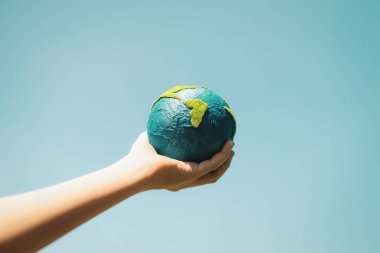 Dünya gezegenini ESG ilkesi ve çevre dostu enerjisiyle daha parlak bir gelecek için Dünya günü olarak tutan genç çocuklar. Döngü