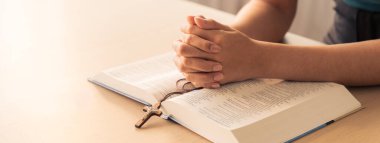 Asyalı erkek, kutsal İncil 'in üzerinde el pençe divan dururken dua etti. Ruhani, dini, inancı, ibadeti, Hıristiyanlığı ve Tanrı 'nın kutsamasını. Geçmişi bulanıklaştırıyor. Filizlenen.