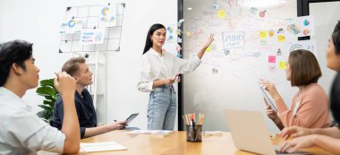 Genç ve güzel lider pazarlama stratejisini sunarken, uzman yatırımcı ve proje yöneticisi de yeni başlayan iş toplantısında iş performansını analiz etmeye çalışıyor. Çok ırklı bir grup. Tertemiz..