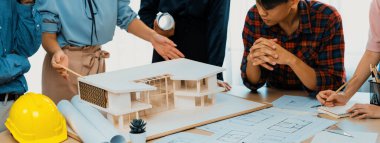 Mimari takım analizi ve ev modeli, plan ve mimari ekipmanlarla toplantı masasında ev inşaatı hakkında beyin fırtınası. Yaratıcı tasarım ve takım çalışması. Filizlenen.