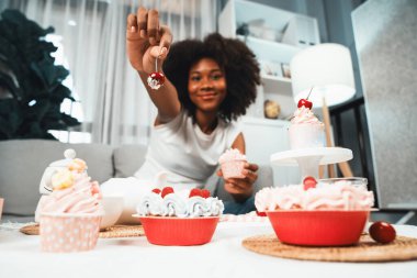 Genç ve güzel Afrikalı blogcu, pastel renkte özel mutfaklar gösteren bir kek sunuyor. Favori tatlı fırın yemeğiyle sosyal medyanın yaratılması. Tatlandırıcı.